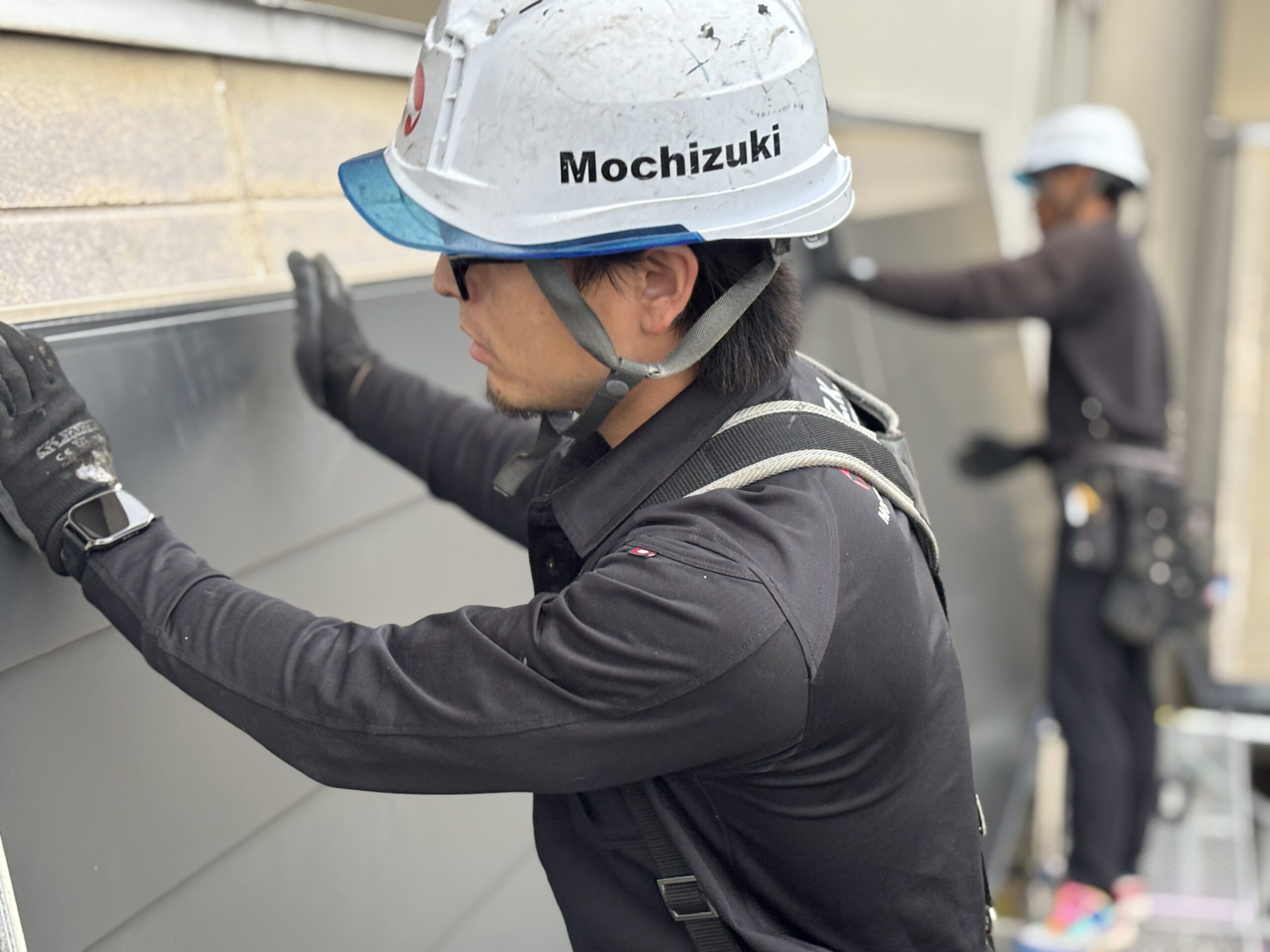上里町の店舗で新しい外壁材を一枚ずつ既存下地へビスで固定する外壁カバー工事
