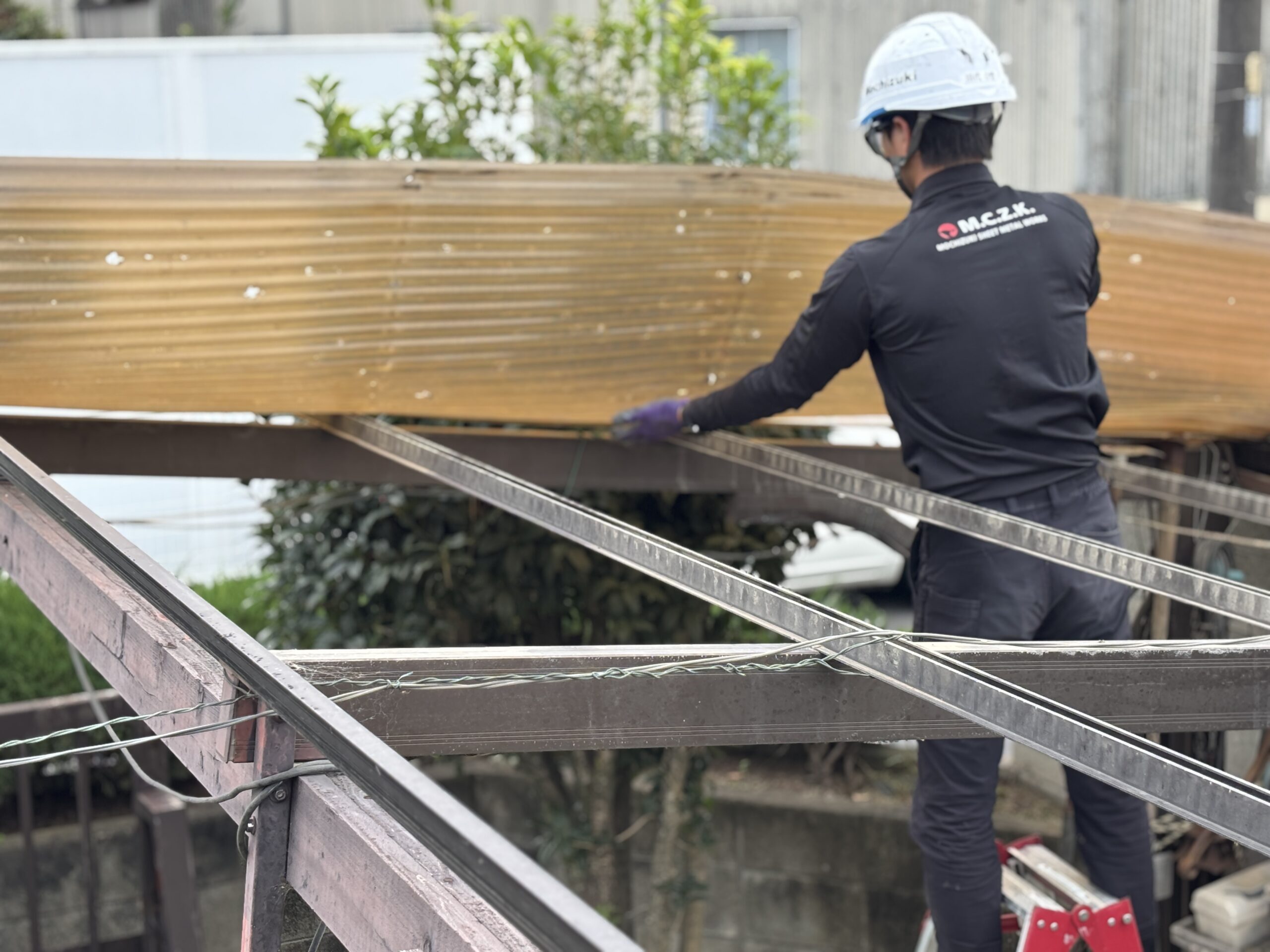 伊勢崎市で雹被害を受けた既存の波板を一枚ずつ撤去する作業